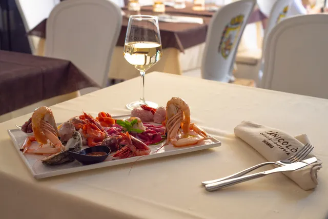 Crudo misto di mare con un calice di vino bianco